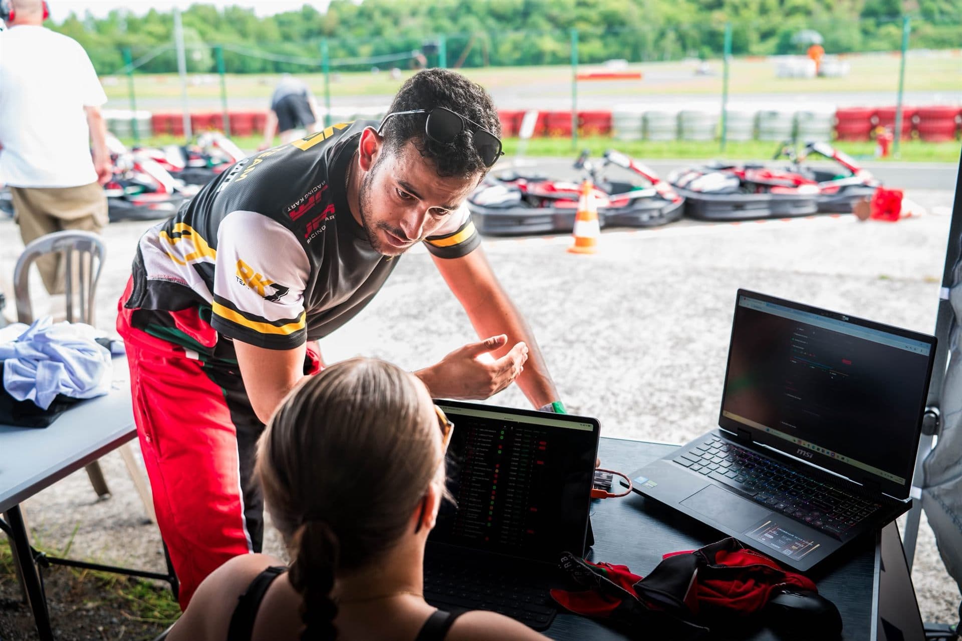 Ingénieur au muret avec PitBoard sur son ordinateur pendant une course